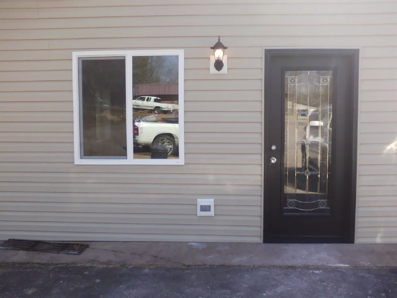 New siding, window and entry door on the side of an addition in San Marcos