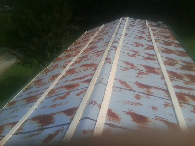 Rusted metal roof panels with new wood purlins before replacement — Storm Damage Roof Repair in San Marcos by Roofing Brothers